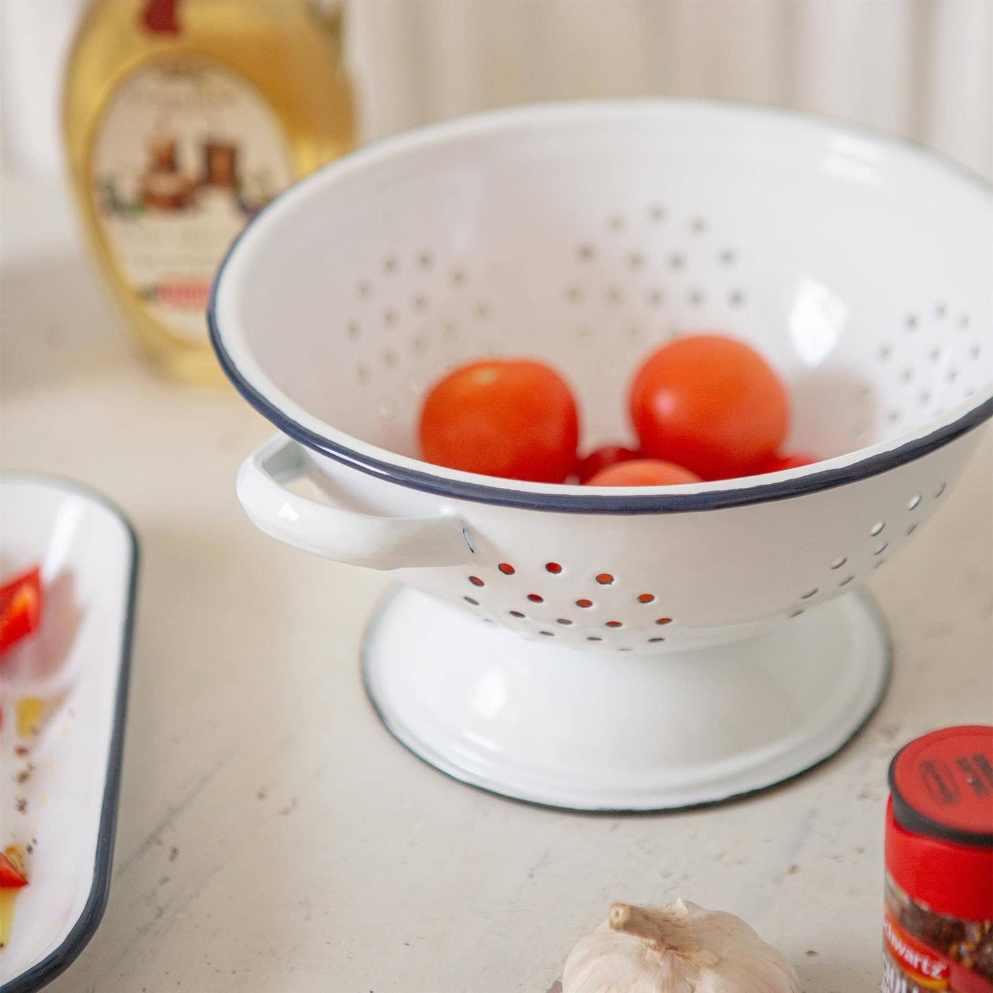 White  enamel colander with blue rim