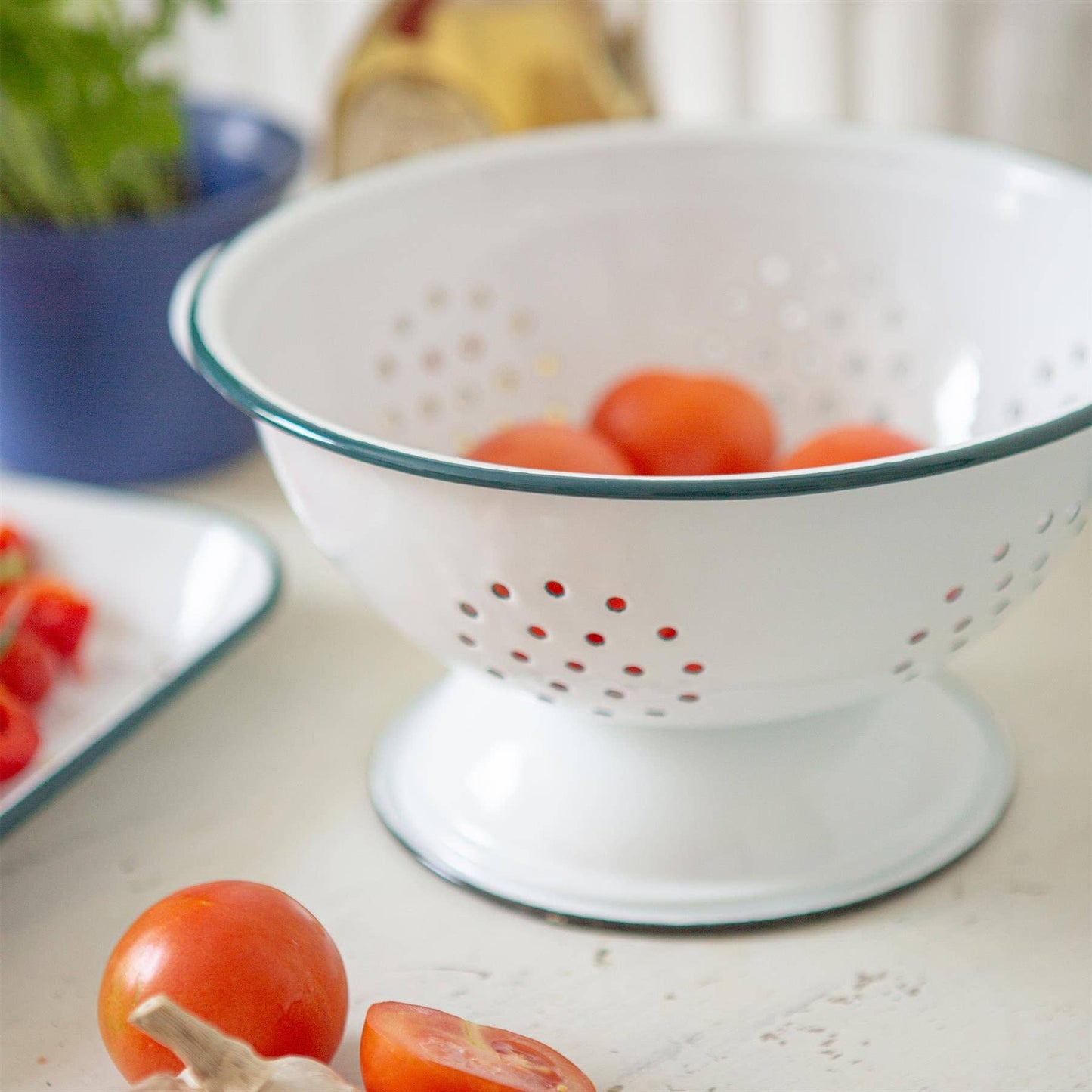 White  enamel colander with blue rim